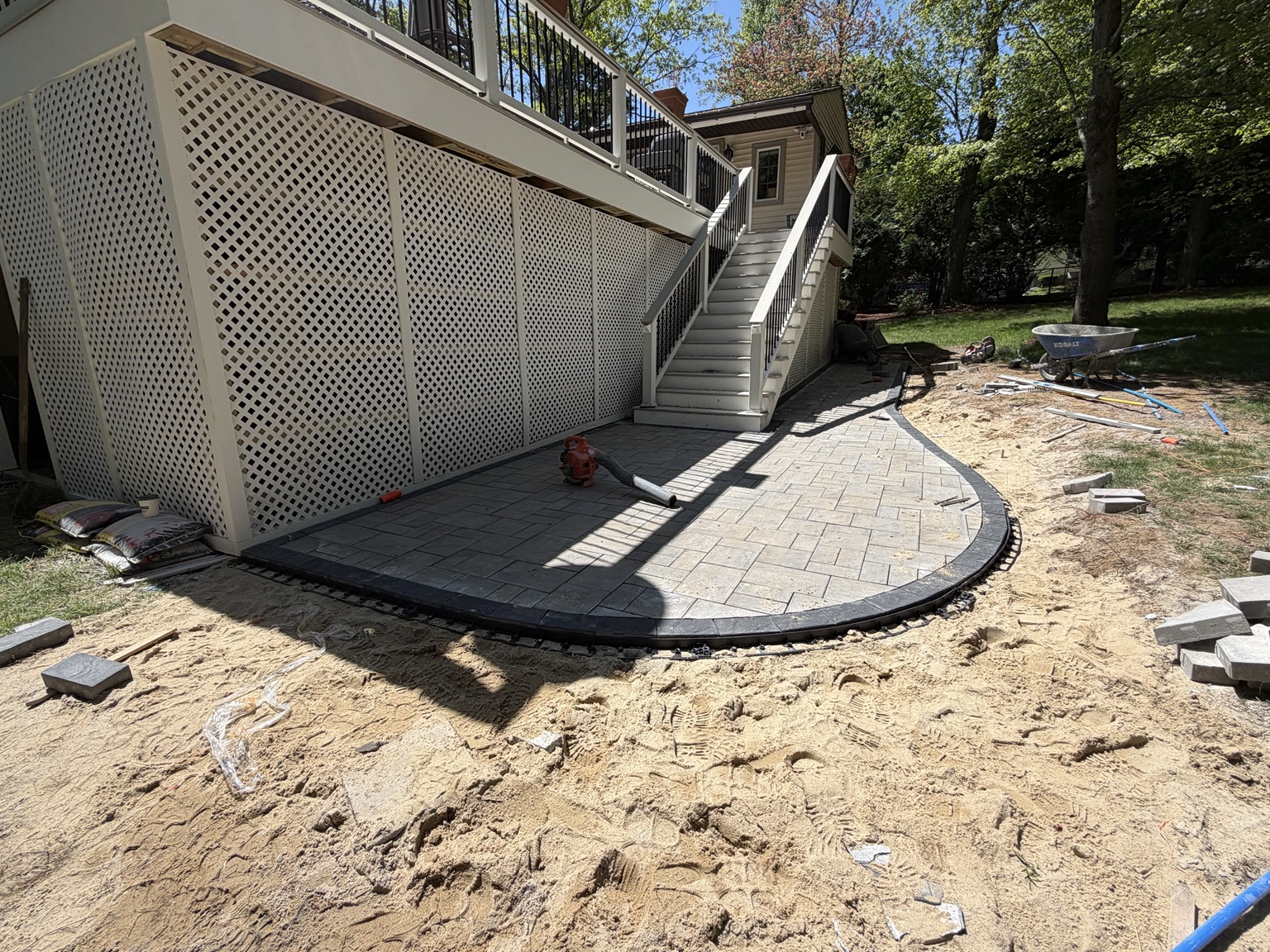 Three-piece paver field and curved coal border installation during Bellingham Massachusetts patio project
